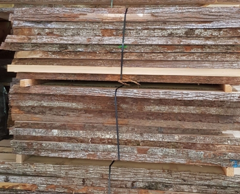 Rohbretter mit Rinde aus Schweizer Holz im Lager der Beer-Holz AG in Meiringen Rohbretter mit Rinde aus Schweizer Holz im Lager der Beer-Holz AG in Meiringen
